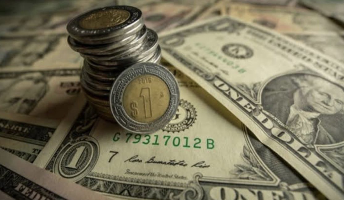 Monedas de peso sobre billetes de un dólar