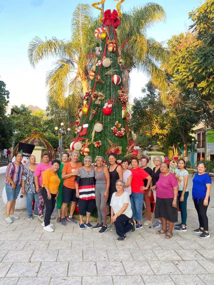 Personas posando en un árbol navideño